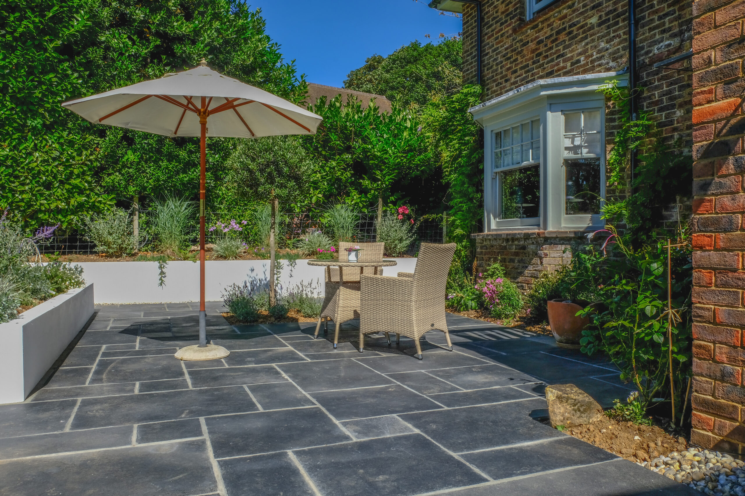 Table and chairs on the patio in an English country garden